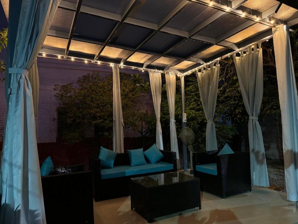 a patio with a couch and curtains and lights at Nani s House - Warmth & Comfort in Dehradun
