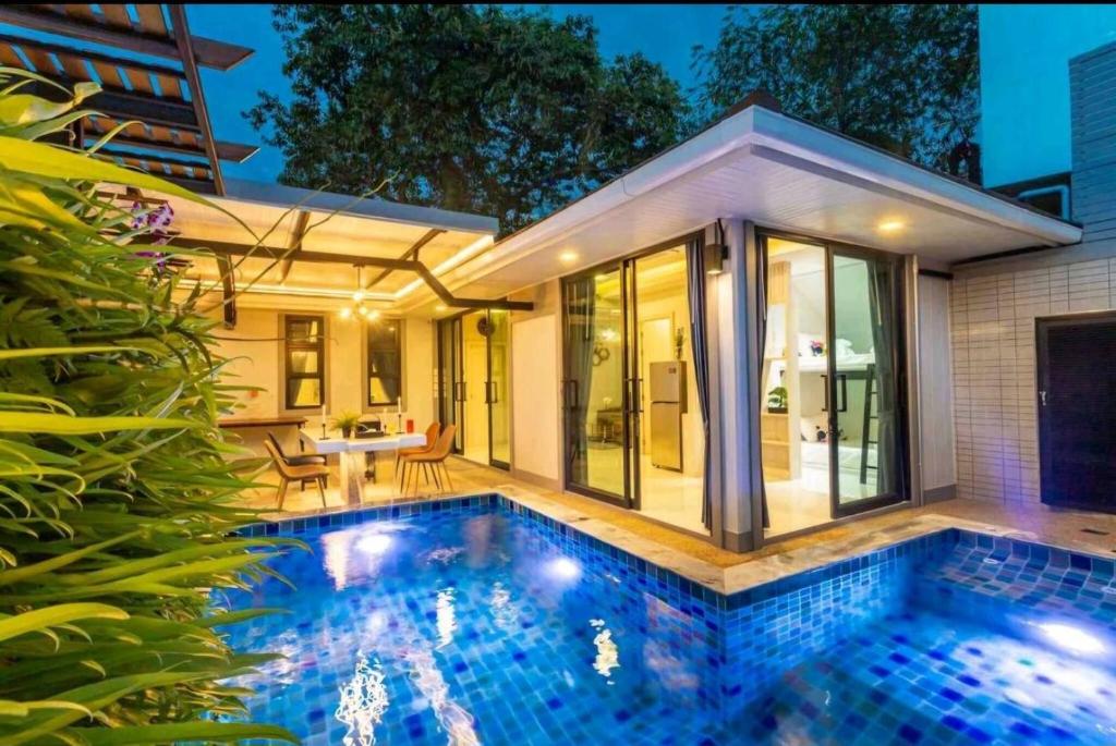 a swimming pool in front of a house at Pool Villa Suchada 3 bedrooms max 7 peoples in Ban Khlong Haeng