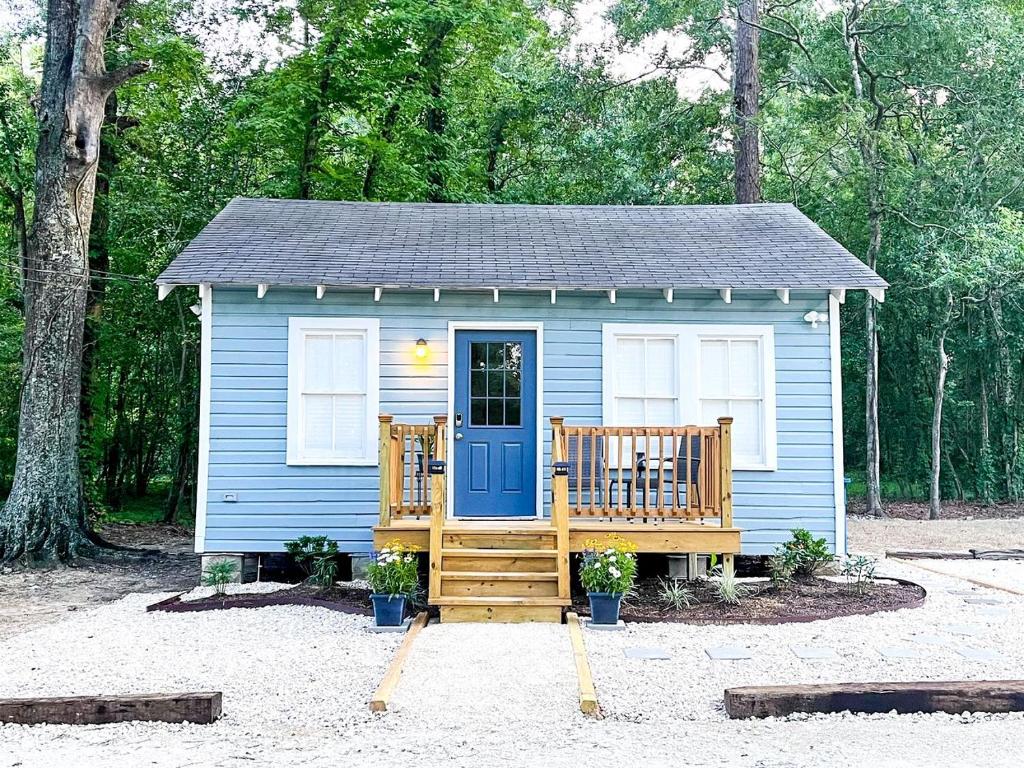 une petite maison bleue avec un porche et une porte bleue dans l'établissement Picturesque Cozy Cottage with Fire Pit Space in Louisiana, à Pilette