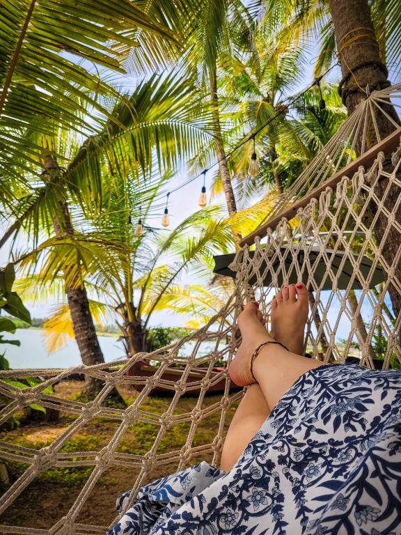 a woman laying in a hammock on a beach at Green Island homestay in Kadalundi
