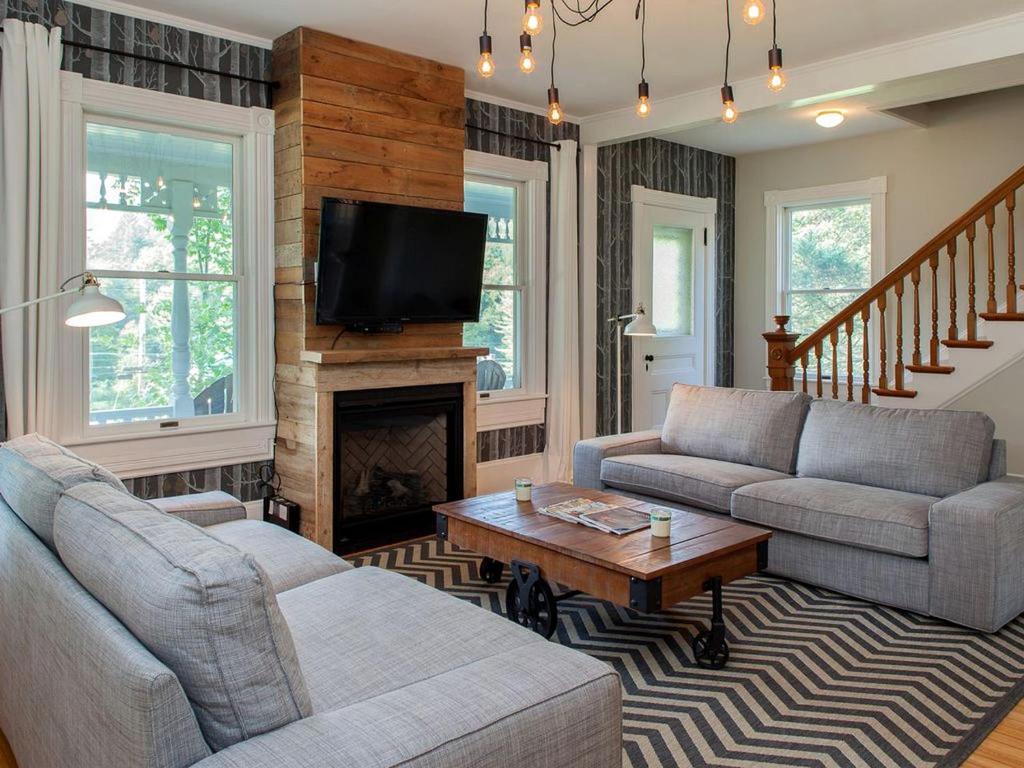 ein Wohnzimmer mit zwei Sofas und einem Kamin in der Unterkunft Modern Luxury Farmhouse with a Jacuzzi Tub near Woodstock, Vermont in Bridgewater