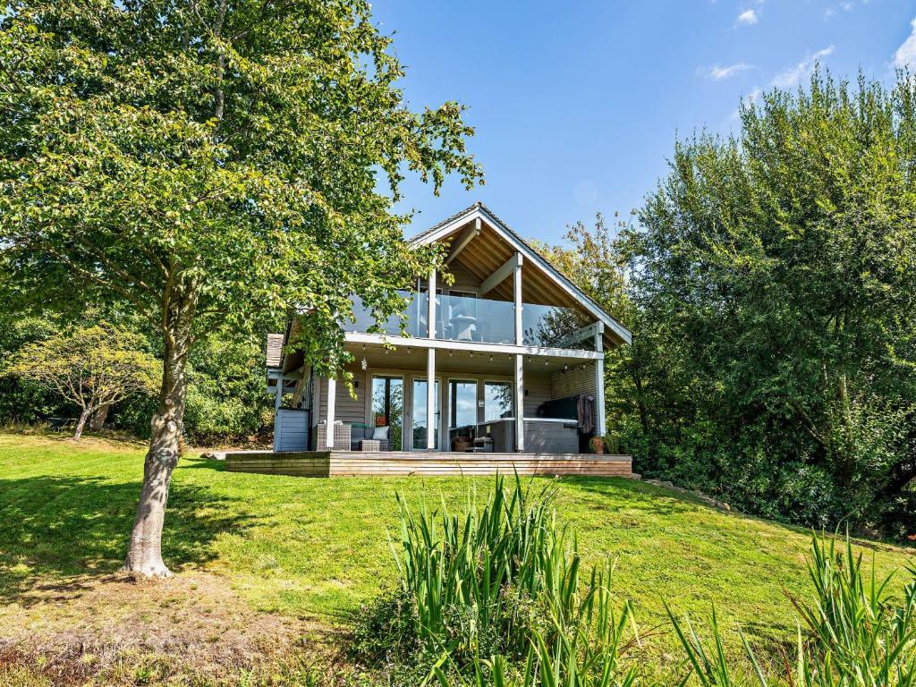 a house on a hill with a tree in the foreground at 3 bed in Harrogate 77577 in Timble