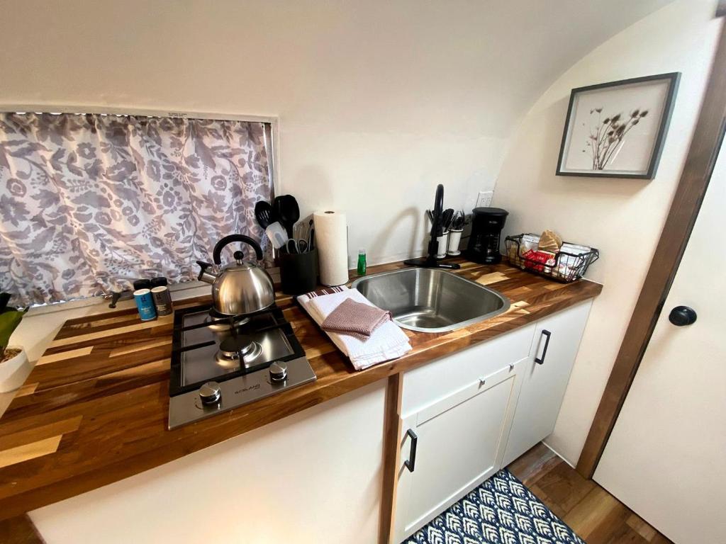 a kitchen counter with a sink and a stove at Retro-Chic Airstream Haven: Your Ultimate Glamping Escape in Colorado in Grand Junction