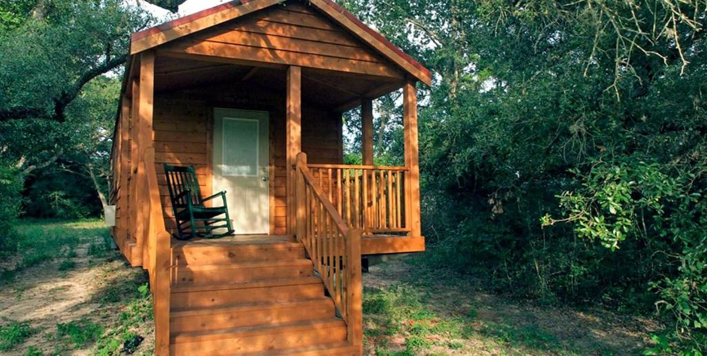 a wooden cabin with a staircase and a porch at Secluded Cabin Perfect for a Romantic Getaway in Austin County, Texas in Cat Spring