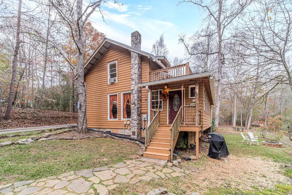 a log cabin with a porch and a staircase at Serene Cabin with Hot-Tub in Cleveland, Georgia in Kinseytown