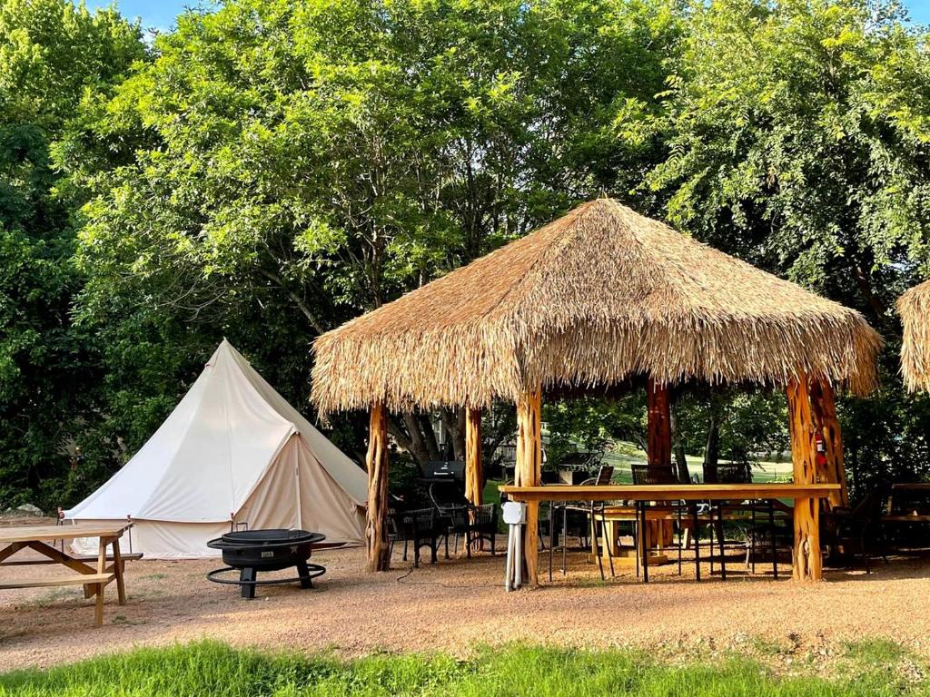a tent and a table and a tent with a teepee at Relaxation and Fun Combined Glamping Tents M & In-Water Picnic Table L in Kingsbury, TX in Second Crossing