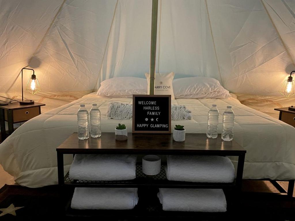 un lit dans une tente avec une table avec un panneau dessus dans l'établissement Beautiful Bell Tents for Lakeside Glamping near Knoxville, Tennessee, à Bean Station