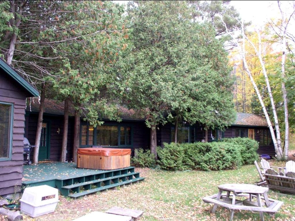 una casa con un tavolo da picnic e un albero di Waterfront Lodge Ideal for Water Activities in Wilmington, NY a Wilmington