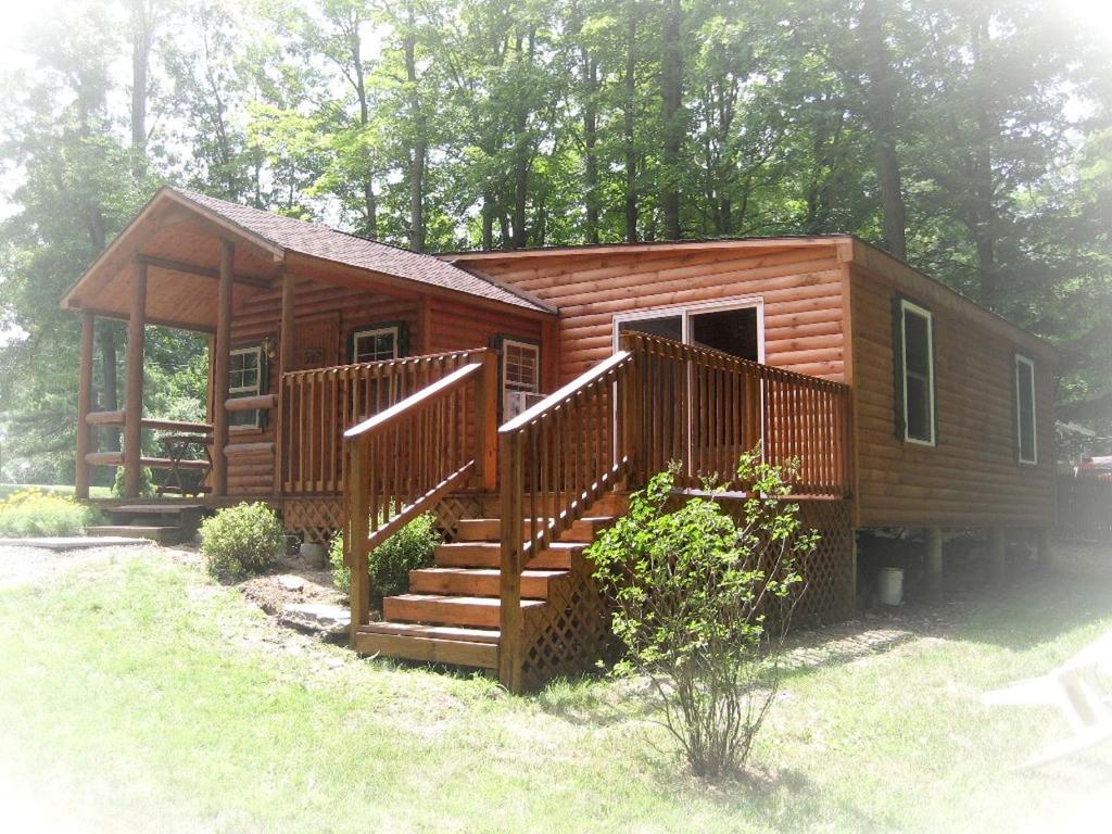 a log cabin with a staircase in the woods at Romantic Cabin Rental with Wi-Fi near Lake Ontario in Sackets Harbor, New York in Sackets Harbor