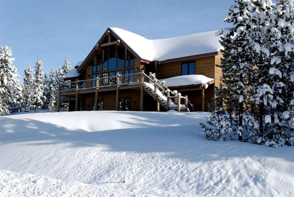 a house with snow on the ground in front of it at Family-Friendly Cabin Rental with Lone Peak Views in Big Sky in Big Sky Mountain Village
