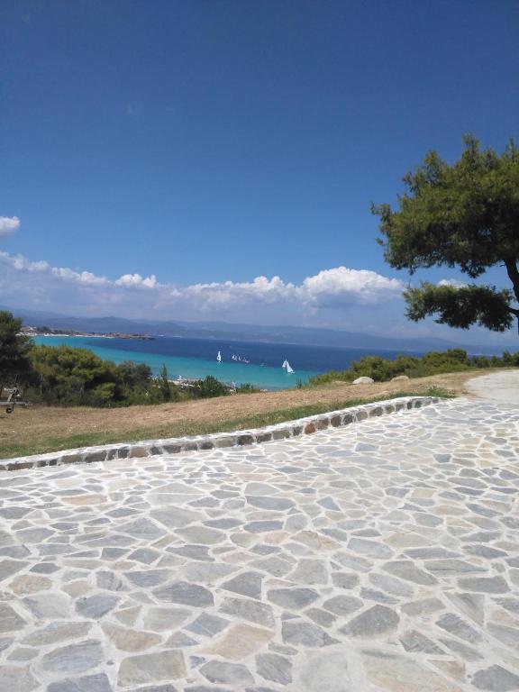 a stone walkway with the ocean in the background at Dasea Houses in Ormos Panagias