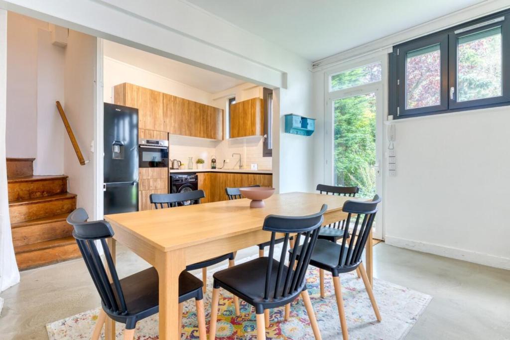 a kitchen and dining room with a wooden table and chairs at Barthélémy cozy house in the city center in Rouen