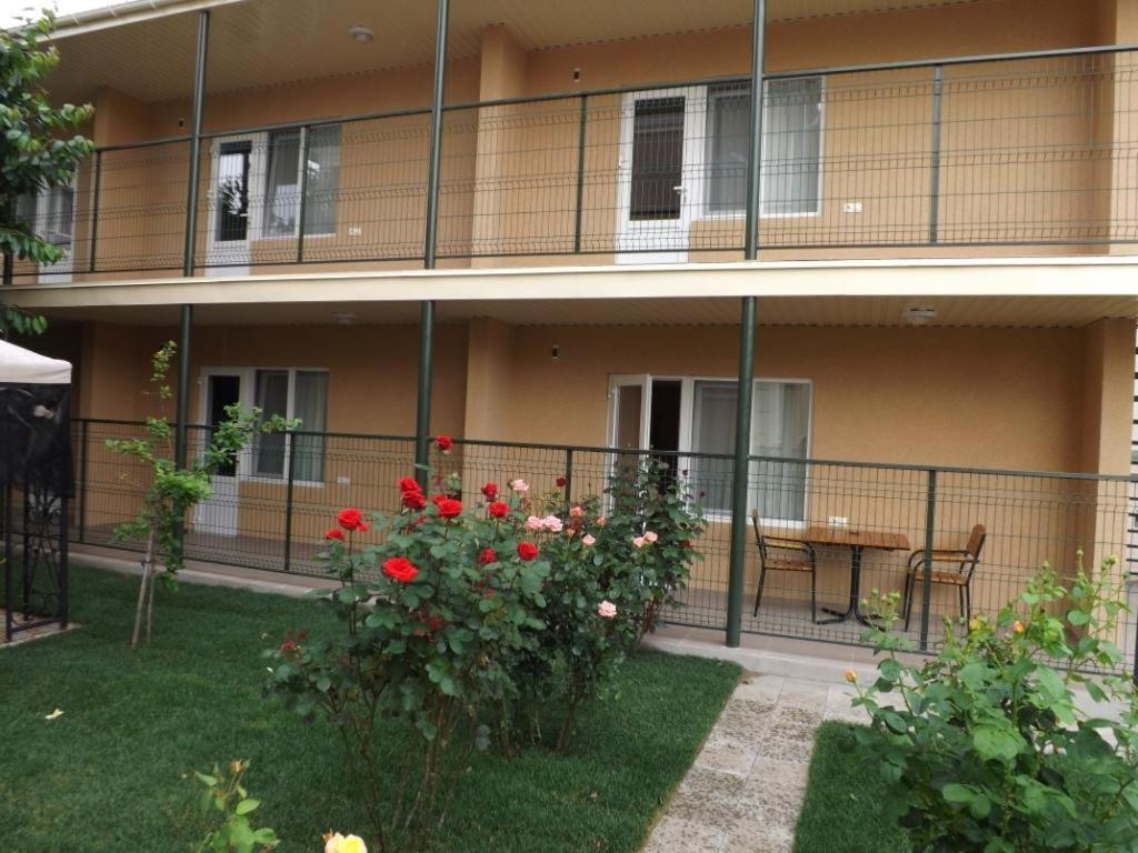 ein Gebäude mit einem Balkon mit einem Tisch und Blumen in der Unterkunft Mini-Otel Luch in Odessa