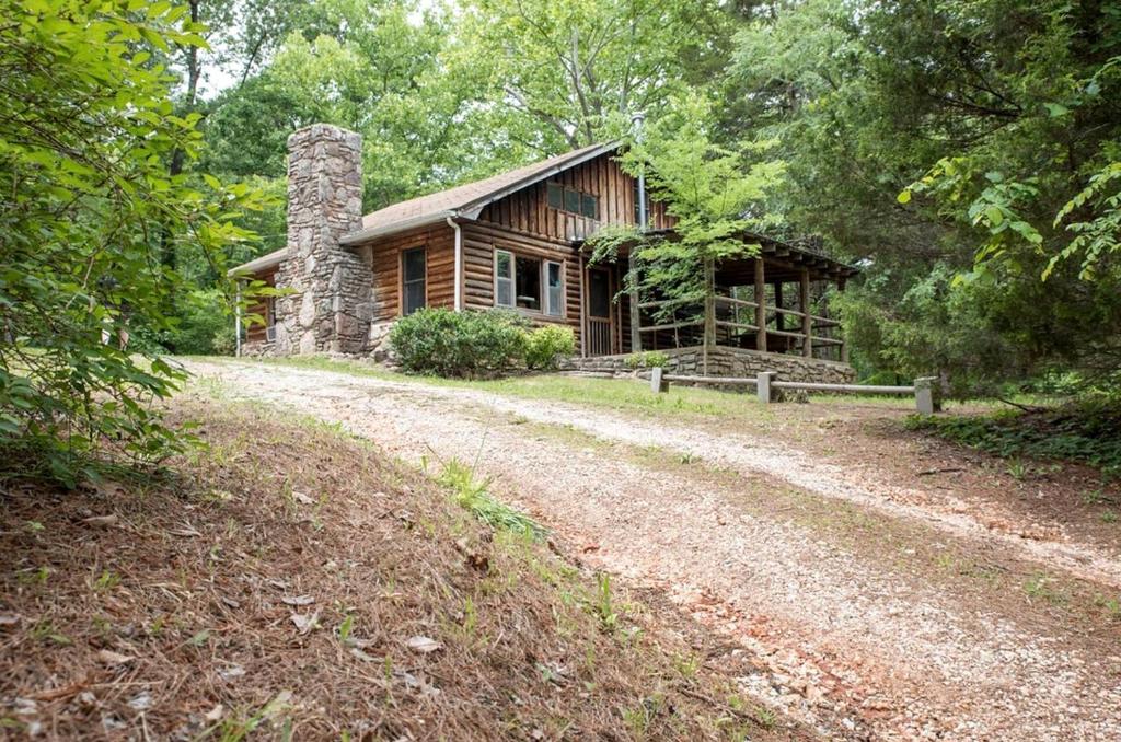 a log cabin with a dirt road in front of it at Pet-Friendly Cabin Retreat in the Ozarks of Scenic Newton County, Arkansas in The Basin