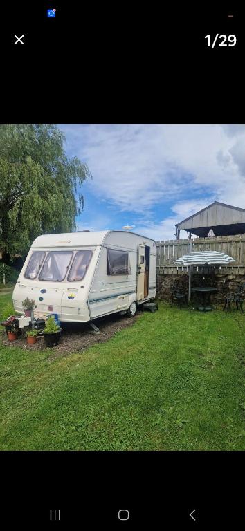 a white caravan parked in a yard next to a fence at Parkhouse farm caravan in Easby