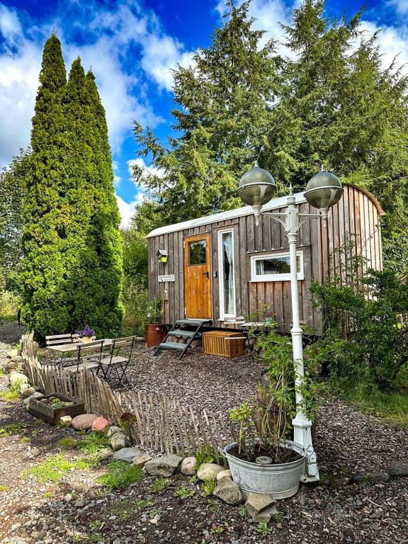 a small shed with a porch and a street light at Wonderful Tiny House Perfect for a Unique Glamping Experience in Germany in Vorpochten