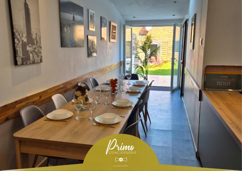 a dining room with a long table and chairs at Le Repère - Maison 5 Chambres proche Vieux Lille in Tourcoing