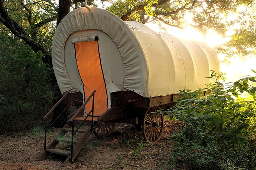 a train car with an orange door on a cart at Unique Wagon Accommodation at Bed and Breakfast near Austin, Texas in Cat Spring