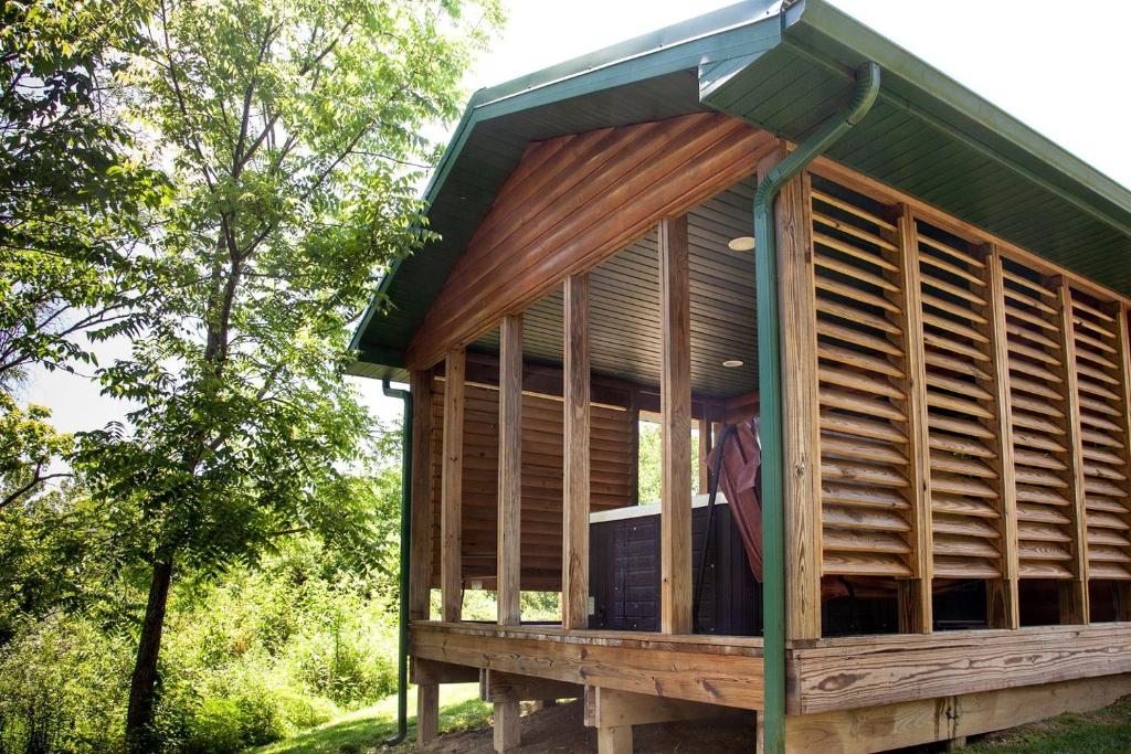 Casa de madera grande con techo verde en Impressive Secluded Cabin with Hot-tub in Herod, Illinois, en Karbers Ridge