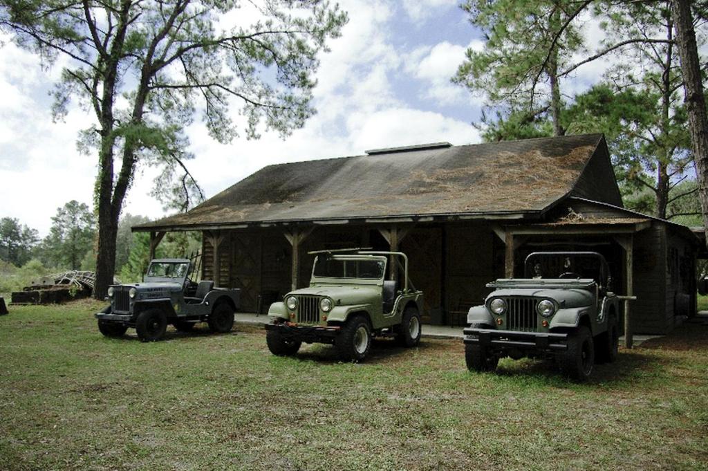 three old trucks parked in front of a building at Secluded Cabin near Ocala National Forest in Central Florida in Fort McCoy