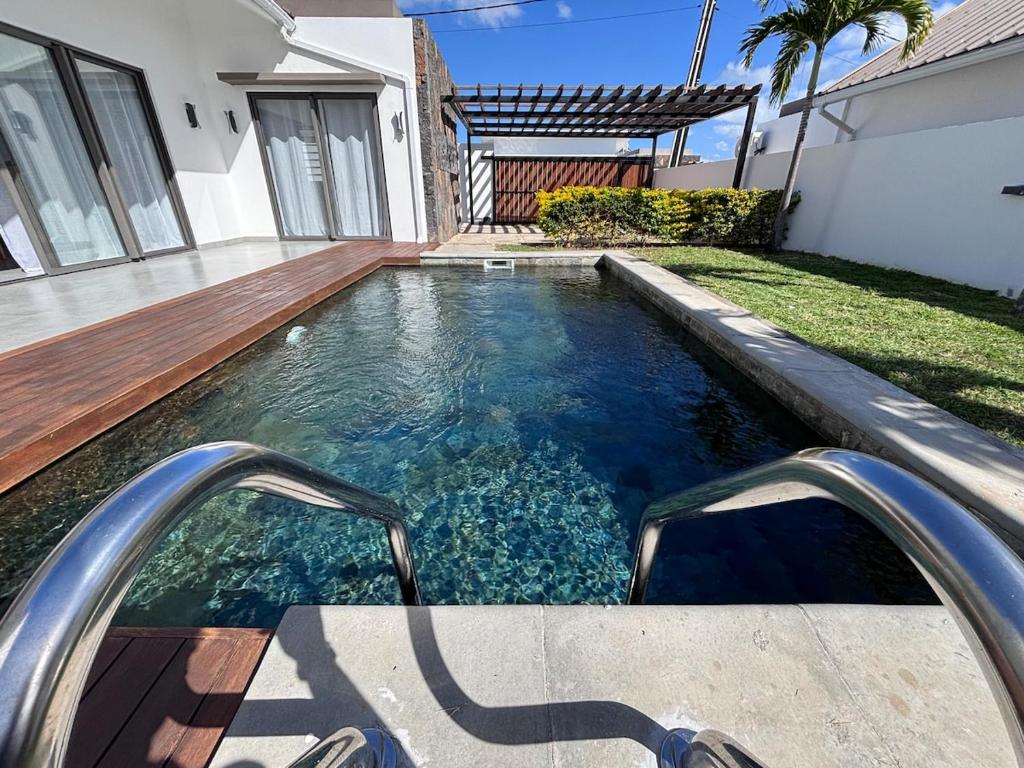 a swimming pool in the backyard of a house at The Royal Vista by SOV in Grand-Baie
