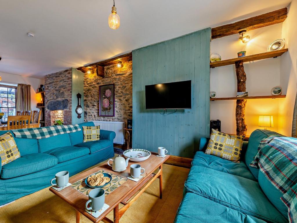 a living room with blue couches and a table at 4 Bed in Bala 94665 in Bala
