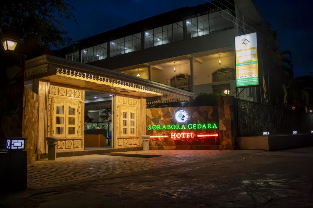 a building with a sign in front of it at night at Sorabora Gedara Hotel in Mahiyangana