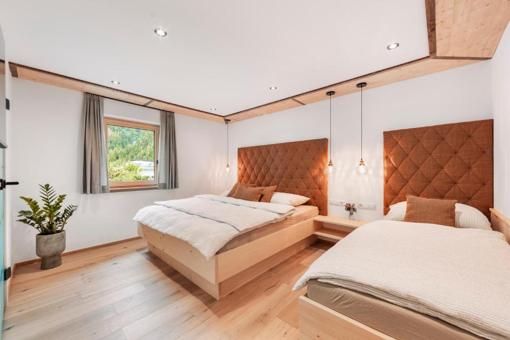 a bedroom with two beds and a window at Chalet-Midl in Umhausen