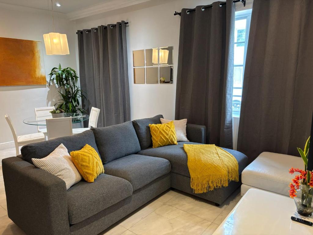 a living room with a gray couch with yellow pillows at Knickerbocker 102 in Miami Beach