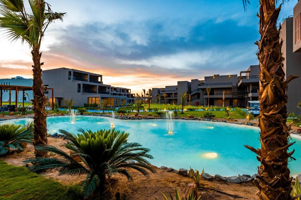 a large pool with palm trees in a resort at Sentido Naga Bay - adults friendly in Hurghada