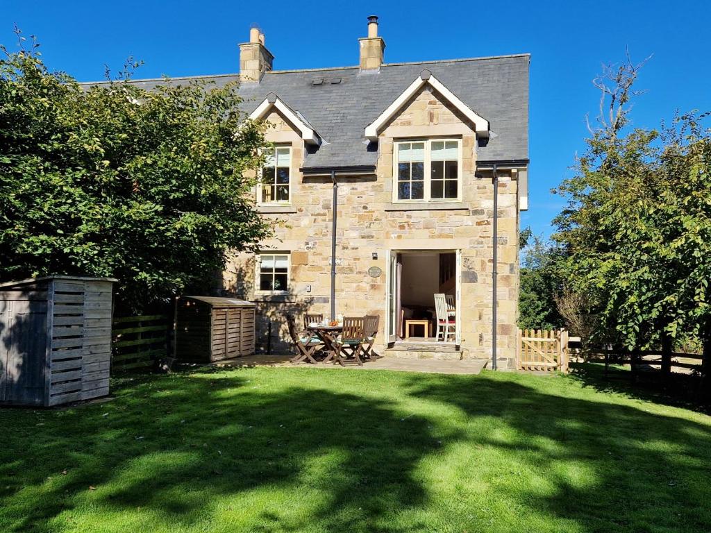 an old stone house with a lawn in front of it at 2 Bed in Nr Beadnell 77990 in Ellingham