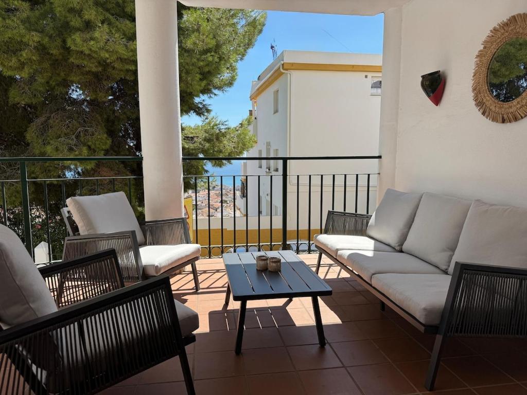 a patio with a couch and chairs and a table at Spacious family friendly 3 bedroom home B' Pueblo - swimming pool - games room & sunny terrasse in Benalmádena