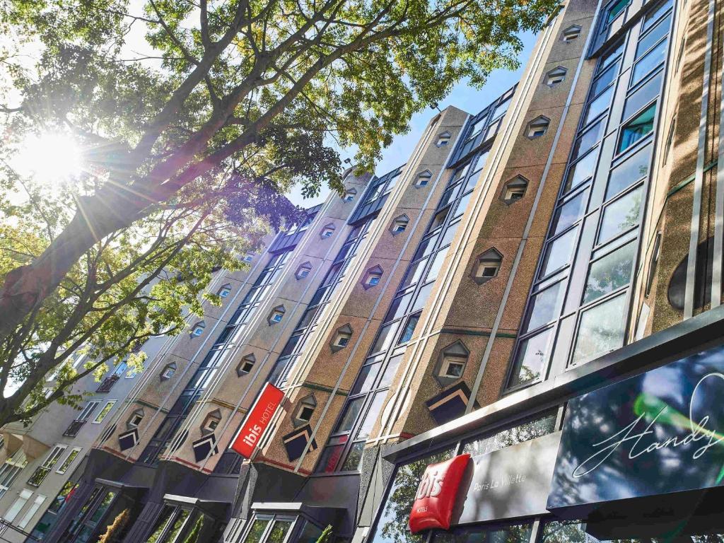 a tall brick building with the sun shining on it at ibis Paris La Villette Cité des Sciences 19ème in Paris