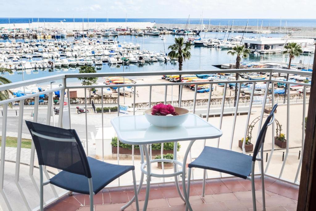 a table and chairs on a balcony with a marina at Vivalidays Joan - Blanes in Blanes