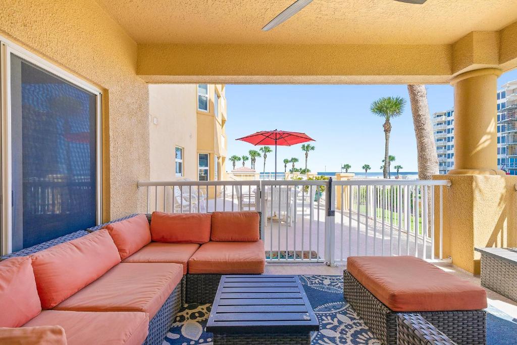 a couch on a balcony with a view of the ocean at Atlantic Villas 103 in New Smyrna Beach