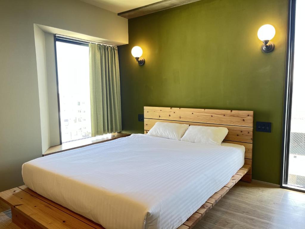 a bedroom with a large white bed with a large window at The Shore Inn in Chatan