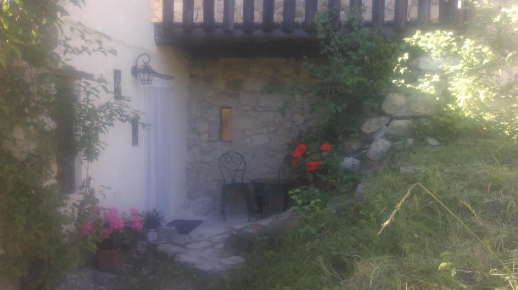 una piccola casa con portico e fiori nel cortile di Chez Corban a Rosans