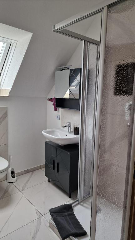 a white bathroom with a sink and a shower at Apartment da Elisa in Rietheim-Weilheim