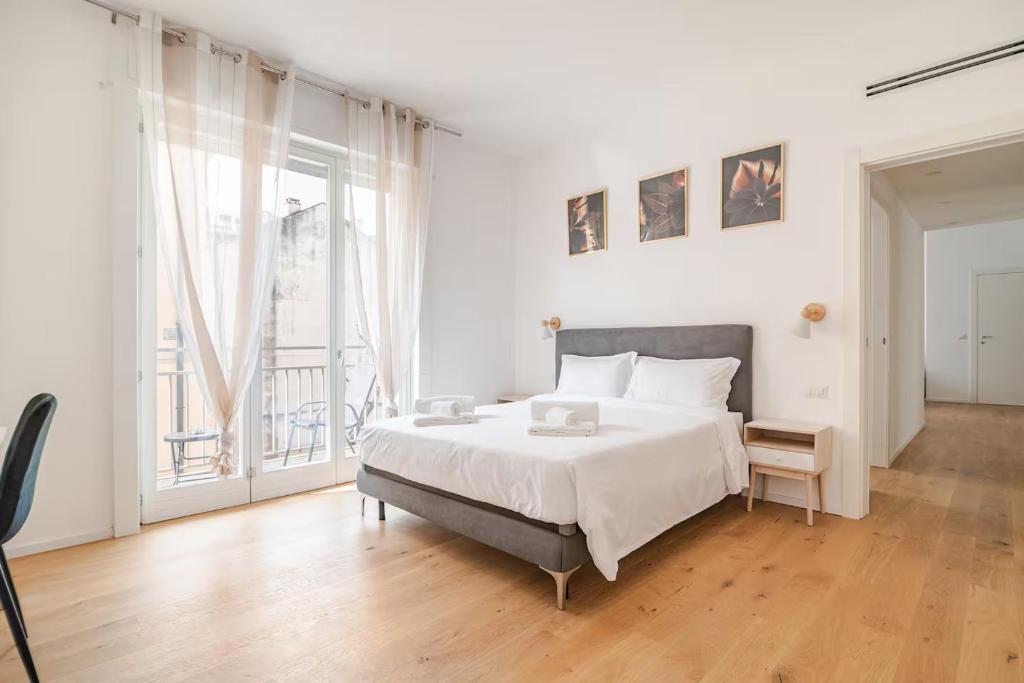 biała sypialnia z łóżkiem i dużym oknem w obiekcie Como Centro Luxury Suite a Pochi passi dal Lago w Como