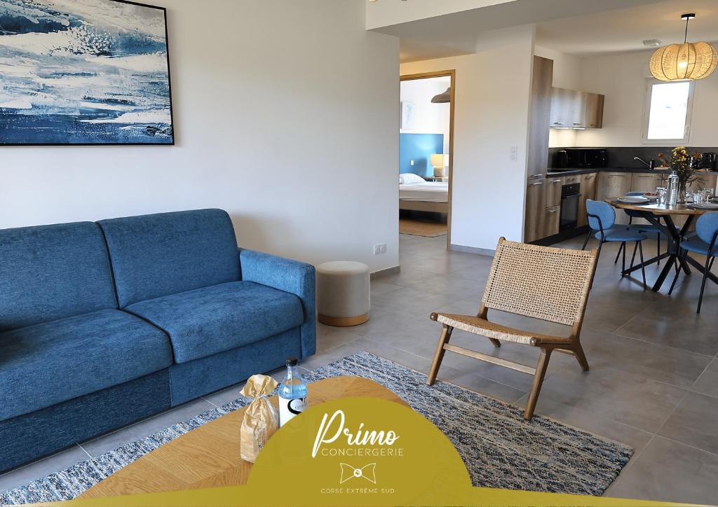 a living room with a blue couch and a table at Villa Tranquille - Maison 4 étoiles 2 Chambres Bonifacio in Bonifacio