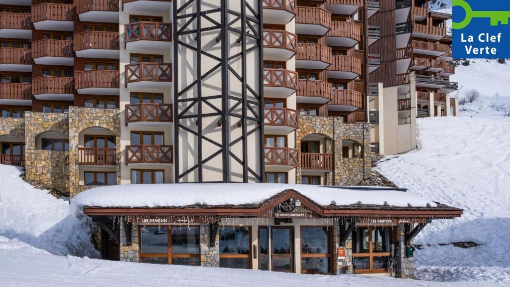 a building with snow on the ground in front of it at Résidence Pierre & Vacances Les Néréides in Belle Plagne