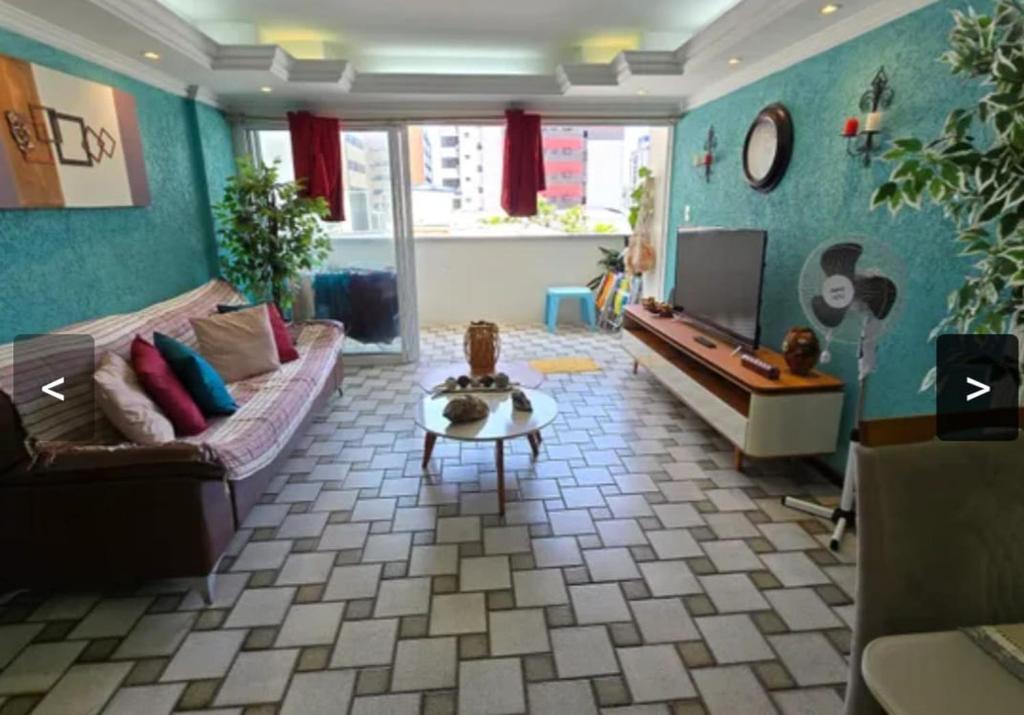 a living room with a couch and a tv at Apartamento em Maceio, uma quadra da praia in Maceió