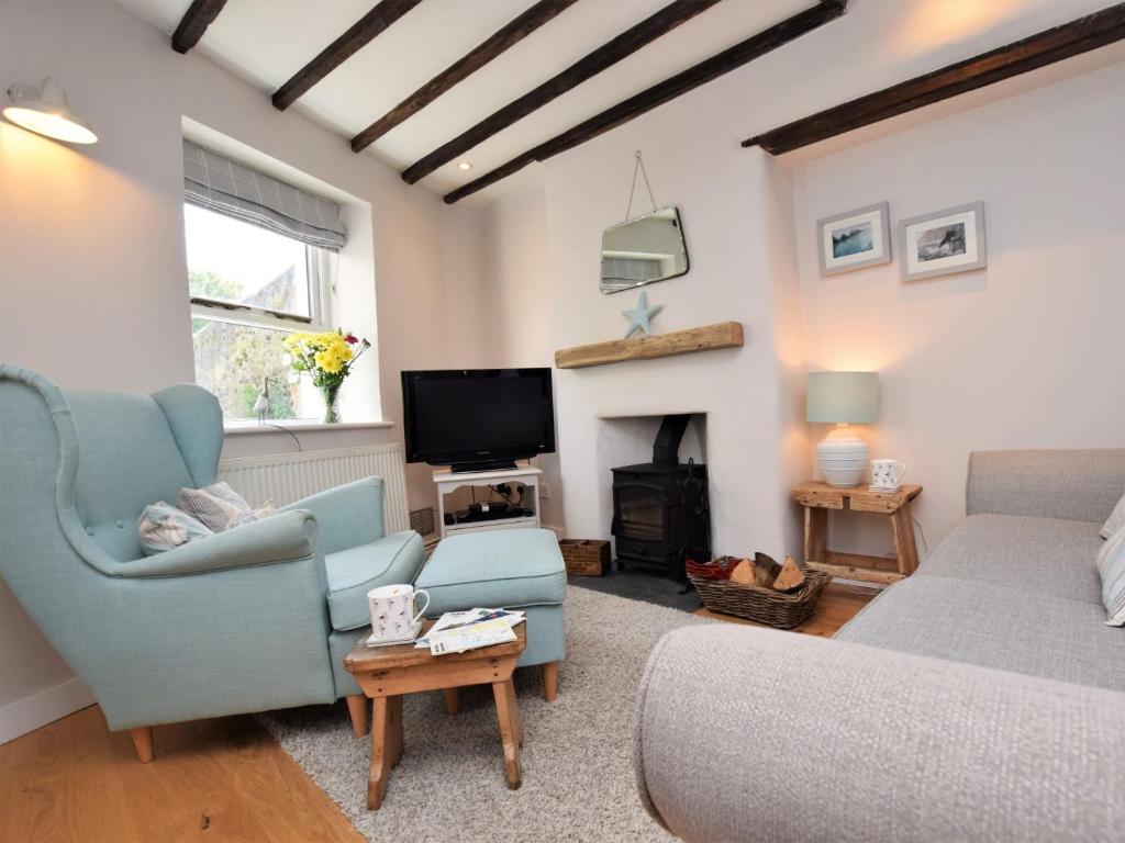 a living room with a couch and a fireplace at 2 Bed in Appledore DECKH in Appledore