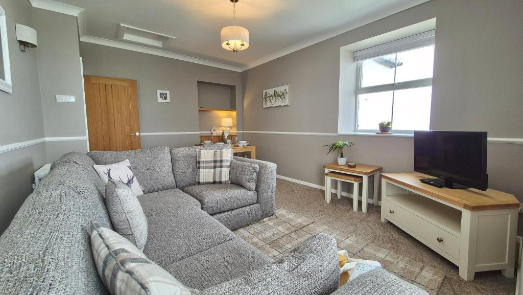 ein Wohnzimmer mit Sofa und Fernseher in der Unterkunft Sunrise Cottage in Llanddulas