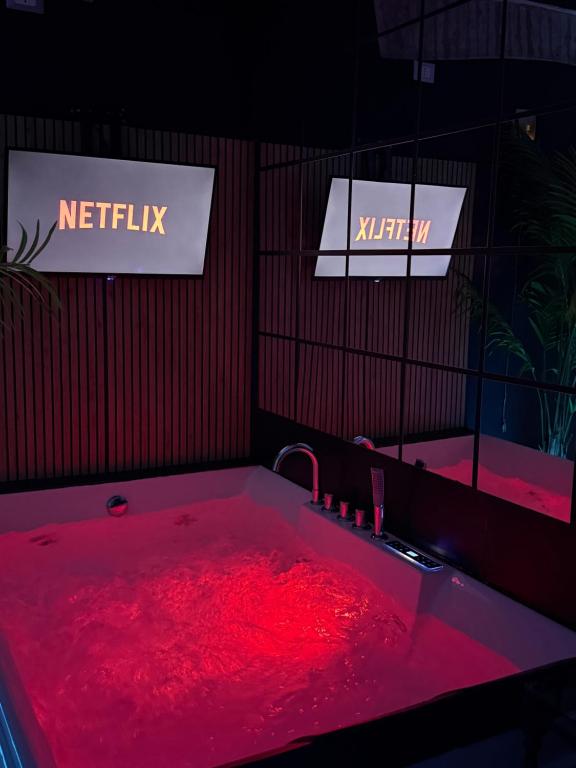 a red tub filled with red liquid next to two signs at AMA Esclusive SPA Madama in Ferrara