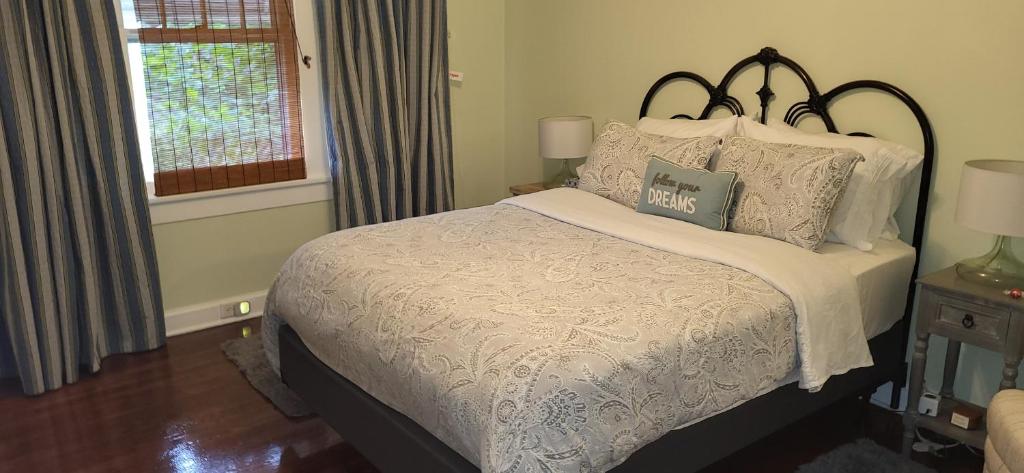 a bedroom with a bed with white sheets and pillows at The Red Rooster Bungalow in Asheville