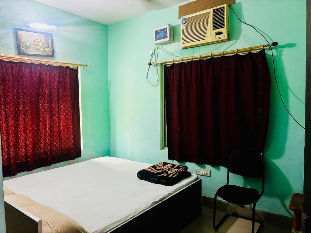 デーオーガルにあるAlkapuri Guest Houseのベッド1台とファン付きの小さな客室です。