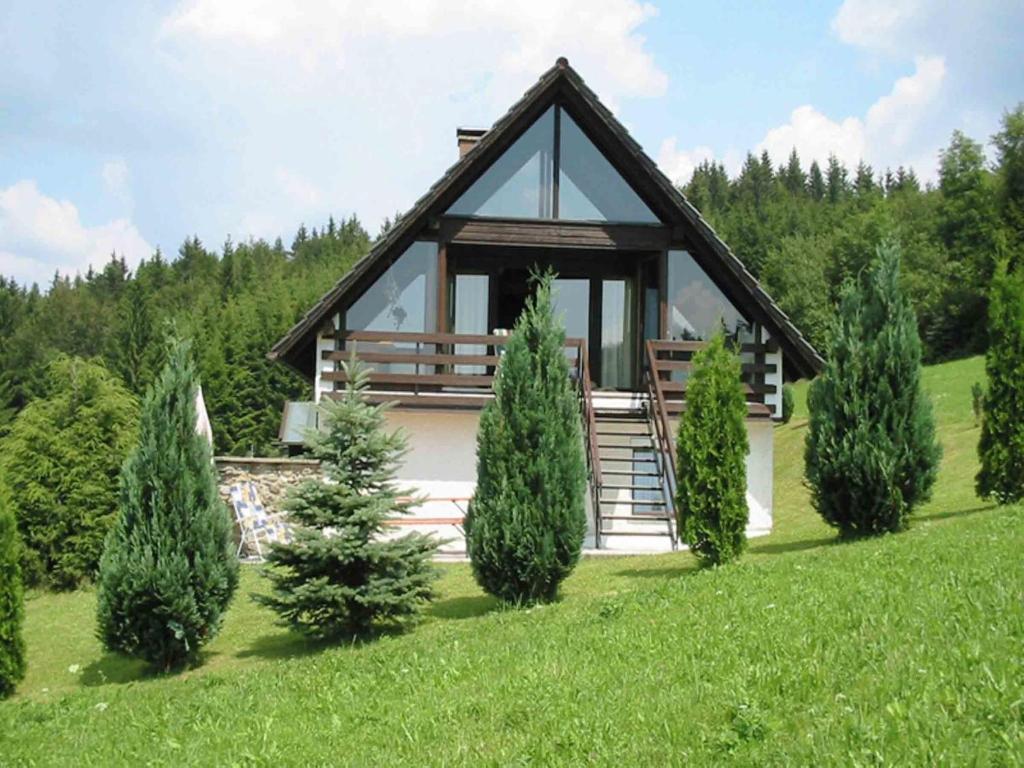 a house in the middle of a field with trees at Ferienhaus im Bayerischen Wald in Schöfweg