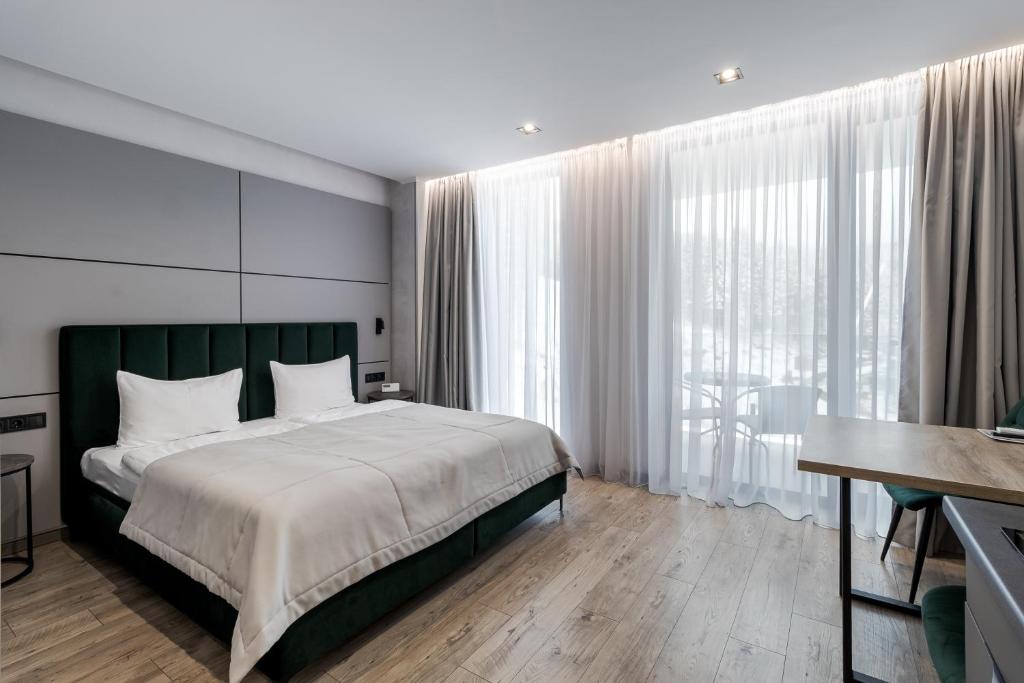 Un dormitorio con una cama y una ventana grande. en Rest&Ski Spa Resort, en Bukovel