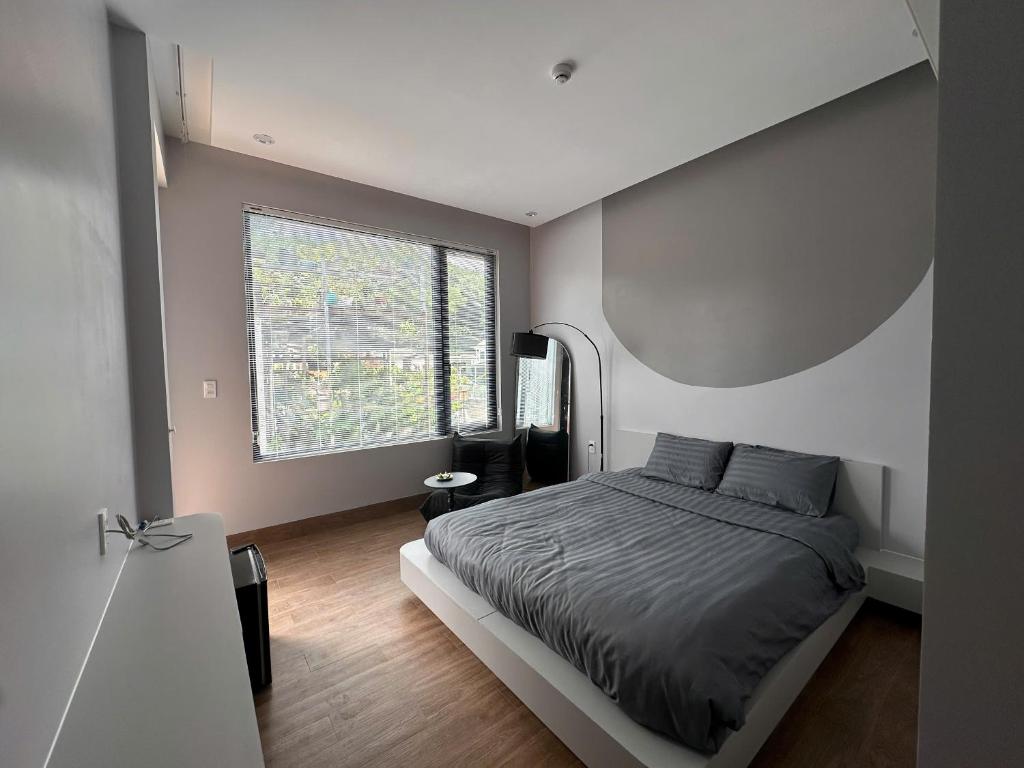 une chambre avec un lit et une grande fenêtre dans l'établissement Núi Homestay Huế, à Hue